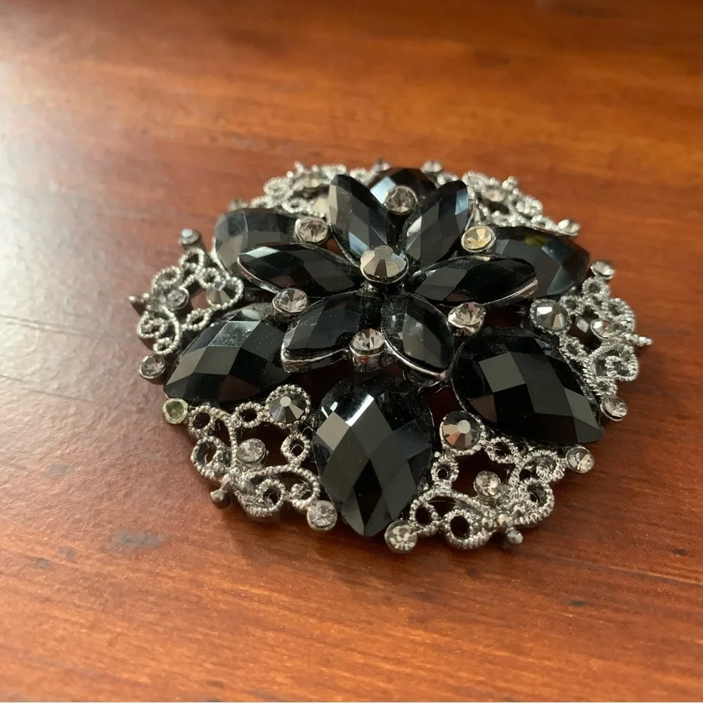 Black rhinestones flower brooch with silver tone filigree